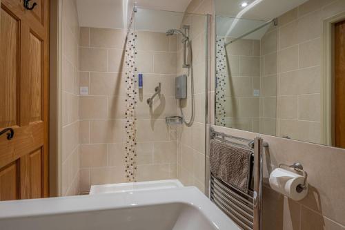 a bathroom with a shower and a white sink at Primrose Cottage in Whitby