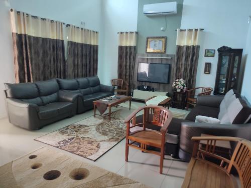 a living room with a couch and a tv at Big Banglo Homestay in Bedung