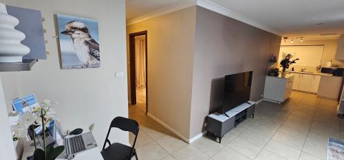 a living room with a tv on a wall at Spacious 5-bed house opposite IGA & Golf Course in Kalgoorlie