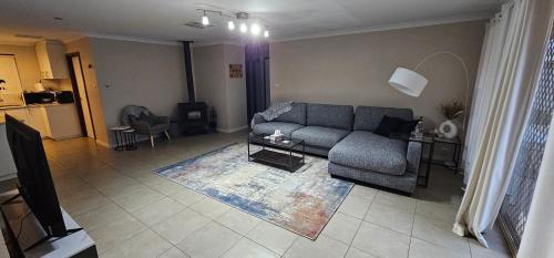 a living room with a couch and a table at Spacious 5-bed house opposite IGA & Golf Course in Kalgoorlie