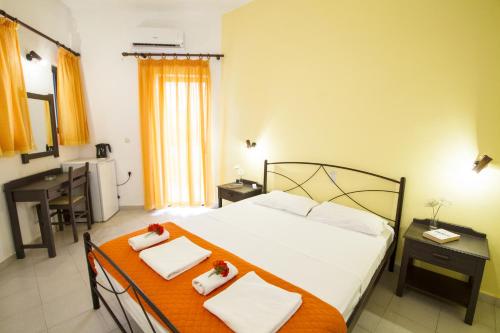 a bedroom with a bed and a table with towels at Kalami Rooms in Falasarna