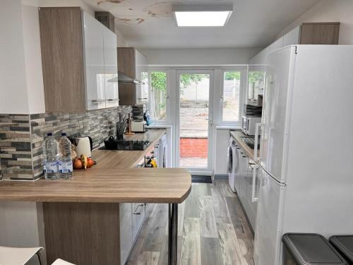 eine Küche mit einem Kühlschrank und einer Holzoberfläche in der Unterkunft Ensuite Room Selly Oak - Milner Road in Birmingham