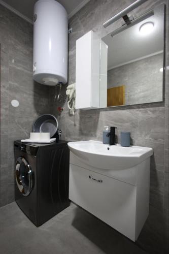 a bathroom with a sink and a washing machine at Enjoy Apartments Prilep in Prilep