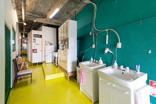 和歌山市にある和歌浦Poseidon家族団体専用個室の緑の壁のバスルーム(シンク2台付)