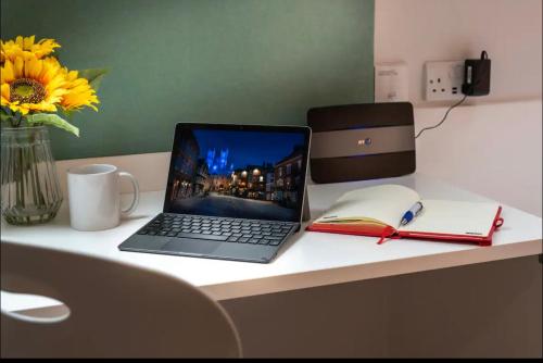 laptopa siedzącego na biurku z książką w obiekcie Pass the Keys Centrally located Studio Apartment w mieście Lincoln