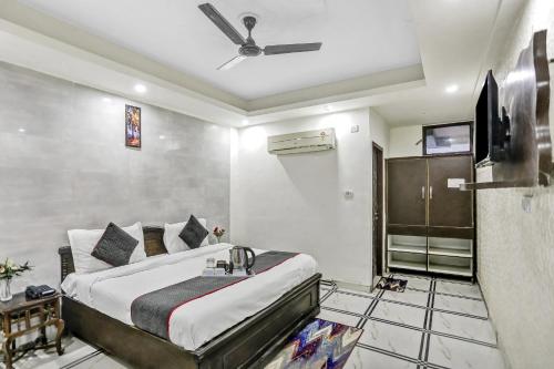 - une chambre avec un lit et un ventilateur de plafond dans l'établissement Collection O 763 AP Grand, à Indirapuram