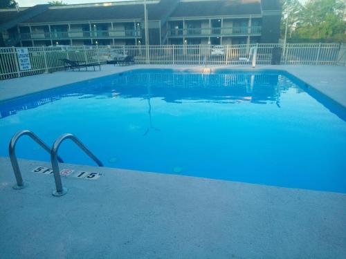 a large blue swimming pool in front of a building at Quality Inn Fort Jackson in Columbia