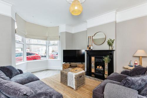 a living room with two couches and a fireplace at Seaside House Llandudno in Llandudno