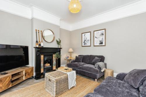 a living room with a couch and a tv at Seaside House Llandudno in Llandudno