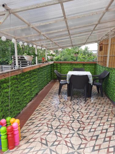patio ze stołem i krzesłami pod pergolą w obiekcie Opál Apartman w Nyíregyházie