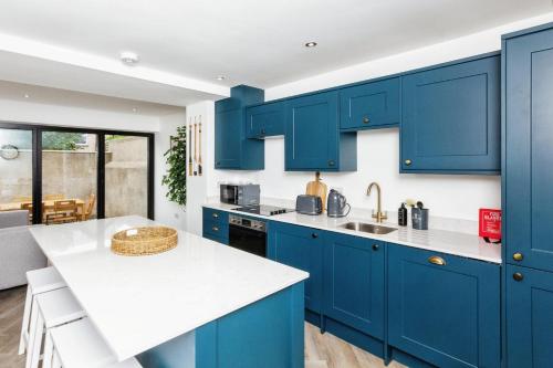 a kitchen with blue cabinets and a white counter top at Seaside House Llandudno in Llandudno