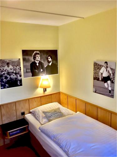 a bedroom with a bed with pictures on the wall at Retro - Art - Hotel Lünen in Lünen