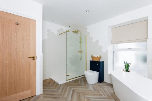 a bathroom with a tub and a shower and a toilet at Seaside House Llandudno in Llandudno