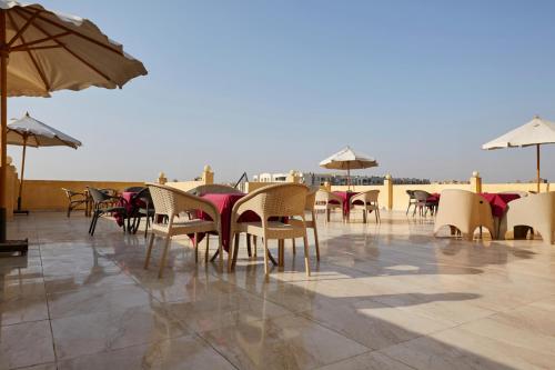 a row of chairs and tables and umbrellas on a patio at Grand Pyramid View Hotel in Cairo