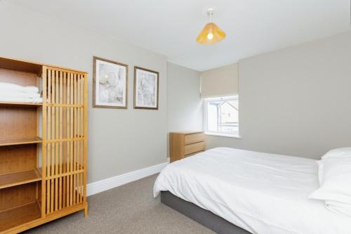 a bedroom with a bed and a book shelf at Seaside House Llandudno in Llandudno
