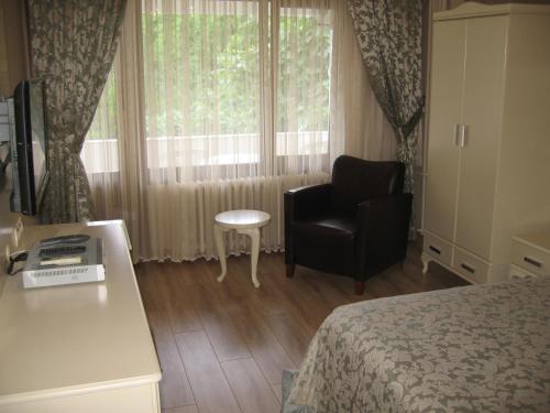 a room with a bed and a chair and a window at Termal Elit Hotel in Gokcedere