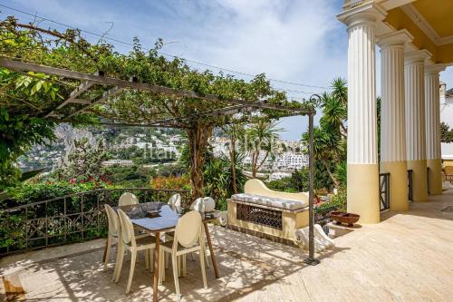 a patio with a table and chairs and a fireplace at Villa 4 Colonne, Capri in Capri