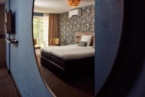 a hotel room with a bed and a mirror at Van der Valk Texel - De Koog in De Koog