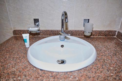 a white sink in a bathroom counter with two cups at Grand Pyramid View Hotel in Cairo