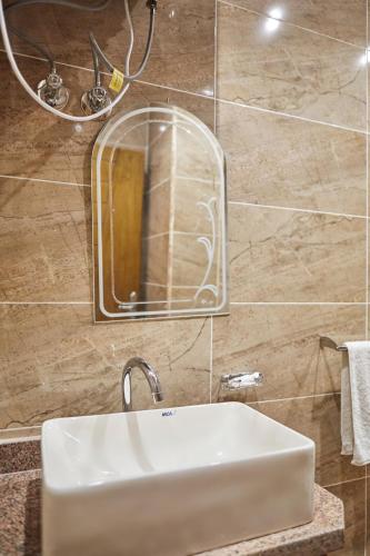 a bathroom with a sink and a mirror on a wall at Grand Pyramid View Hotel in Cairo