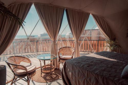 a bedroom with a bed and chairs and a glass table at O'MIR glamping эко-отель Актау in Kyzylkum