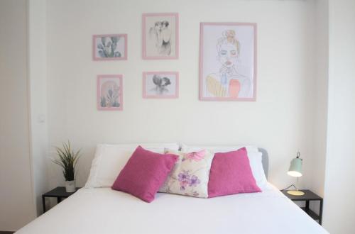 1 dormitorio con cama blanca y almohadas rosas en Republic B&B, en Bitonto
