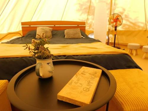 a bed with a table with a sign on it at Tiny House Village Resort 
