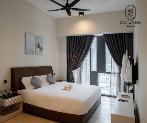 - une chambre avec un lit et une grande fenêtre dans l'établissement AXQUISITE SUITES at KLCC, à Kuala Lumpur