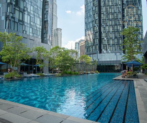 ein Schwimmbad in einer Stadt mit hohen Gebäuden in der Unterkunft AXQUISITE SUITES at KLCC in Kuala Lumpur