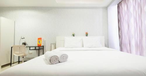 a white bedroom with a white bed and a desk at Cozy & Elegant The Mansion Jasmine Tower Capilano in Jakarta