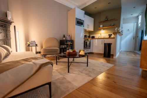 un salon avec un lit et une table et une cuisine dans l'établissement La perle du Marais, à Paris