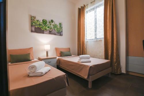 Cette chambre comprend 2 lits et une fenêtre. dans l'établissement Millennium Penthouse with private Hot Tub Gozo, à Għajnsielem