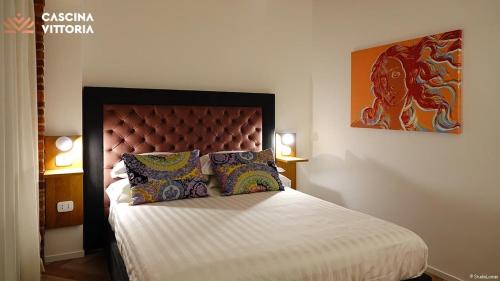 a bedroom with a king sized bed with a dragon painting on the wall at Cascina Vittoria Restaurant Lab & Rooms in Rognano