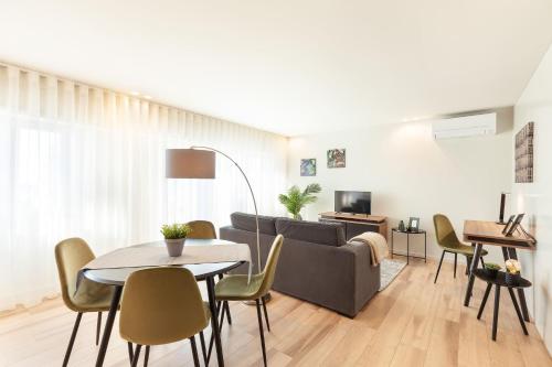 a living room with a couch and a table and chairs at ALL4Braga - Minho's Guest in Braga