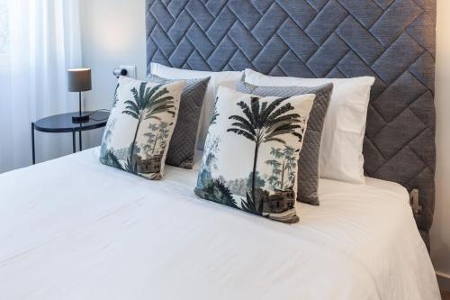 a bed with four pillows with palm trees on it at ALL4Braga - Minho's Guest in Braga