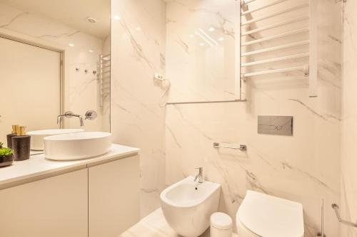 La salle de bains blanche est pourvue de toilettes et d'un lavabo. dans l'établissement ALL4Braga - Minho's Guest, à Braga