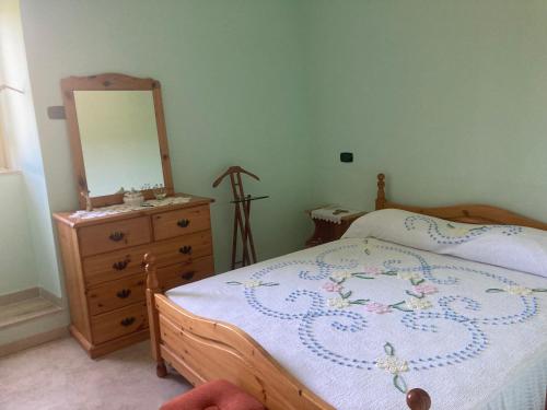 1 dormitorio con 1 cama y vestidor con espejo en La casa nel Feudo, en Tarano
