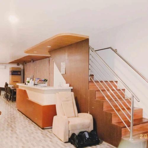 a room with a staircase with a chair and a desk at Mbs Hotel (Maramag Business Suites) in Maramag