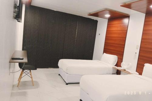 a room with two beds and a black wall at Mbs Hotel (Maramag Business Suites) 