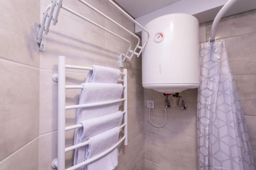ein Badezimmer mit weißen Handtüchern und einer Dusche in der Unterkunft MYFREEDOM Апартаменти Залізничний Вокзал in Kiew