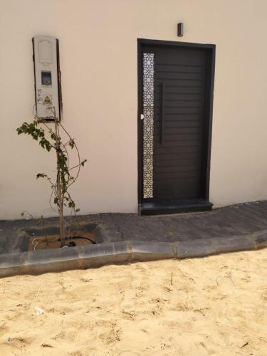 a door with a plant in front of a building at شاليه الجوري in Ilbaras