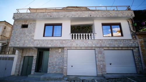 a house with two garage doors in front of it at Vila Fatos Qama in Berat