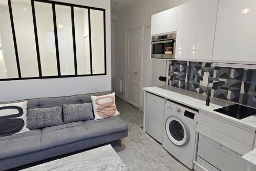 un salon avec un canapé et une cuisine dans l'établissement Lafayette appartement, à Paris