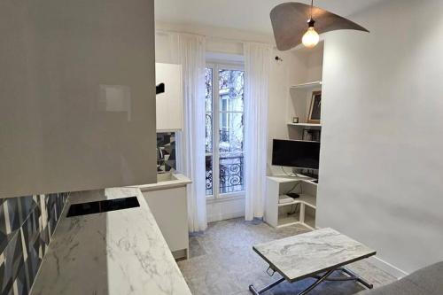 une cuisine blanche avec une table et une fenêtre dans l'établissement Lafayette appartement, à Paris
