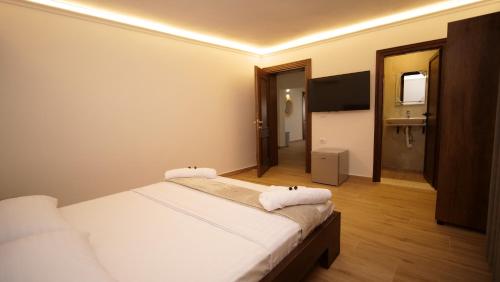 a hotel room with two beds and a television at Vila Fatos Qama in Berat