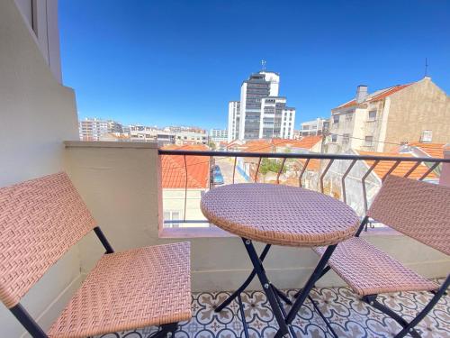 a table and chairs on a balcony with a view at Apartamento Gertrudes in Setúbal
