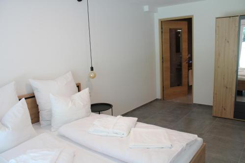 ein weißes Bett mit weißen Kissen in einem Zimmer in der Unterkunft Dinaro Suite, Sauna & Garden in Franzensfeste