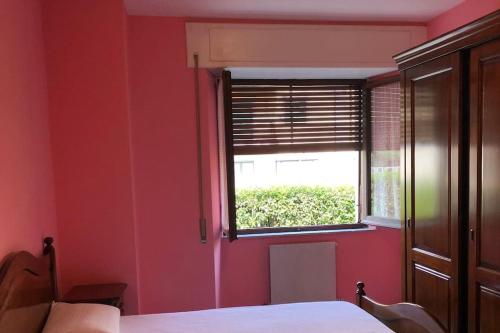 a bedroom with a red wall and a window at Appartamento Jimmy in Pontremoli