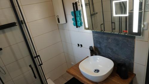a bathroom with a white sink and a mirror at Gemütlicher Bungalow nähe Volksparkstadion in Hamburg
