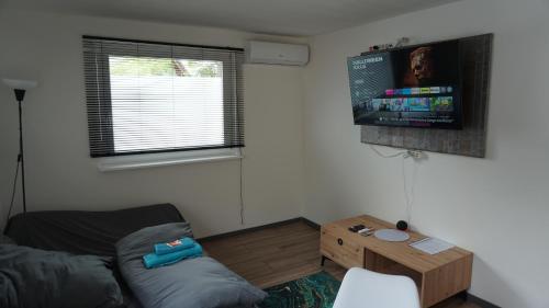 a living room with a couch and a flat screen tv at Gemütlicher Bungalow nähe Volksparkstadion in Hamburg